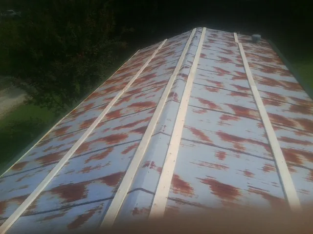 Rusted metal roof panels with new wood purlins before replacement — Storm Damage Roof Repair in Avonmore by Roofing Brothers