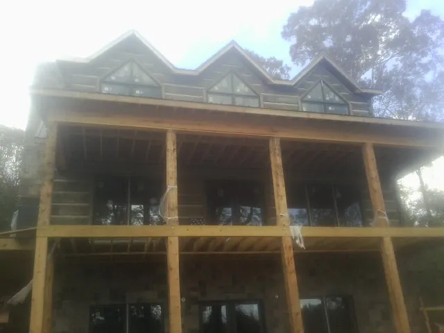 Dormers and porch framing on a large log home under construction — Roof Coating work by our crew in Avonmore