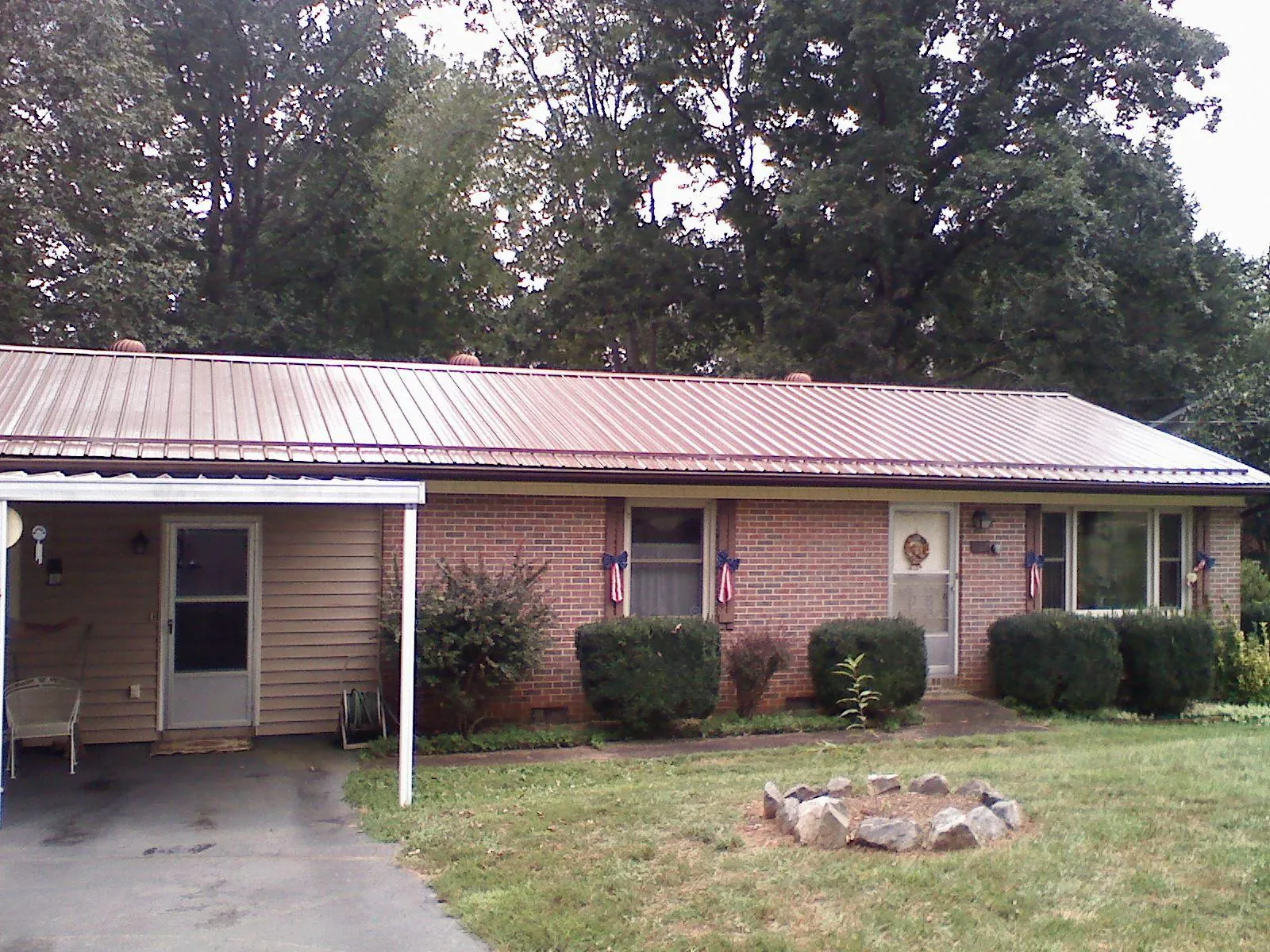 Bronze metal roof and carport on a brick ranch home — Roof Repair work by our crew in Avonmore
